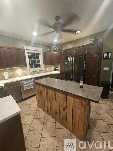 A kitchen with wooden cabinets and a black refrigerator.