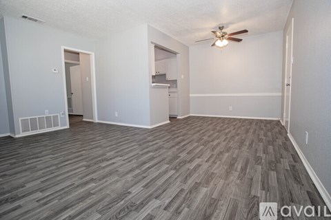 A kitchen area with a refrigerator, cabinets, and a countertop.