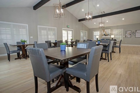 A dining room with a large table and chairs.