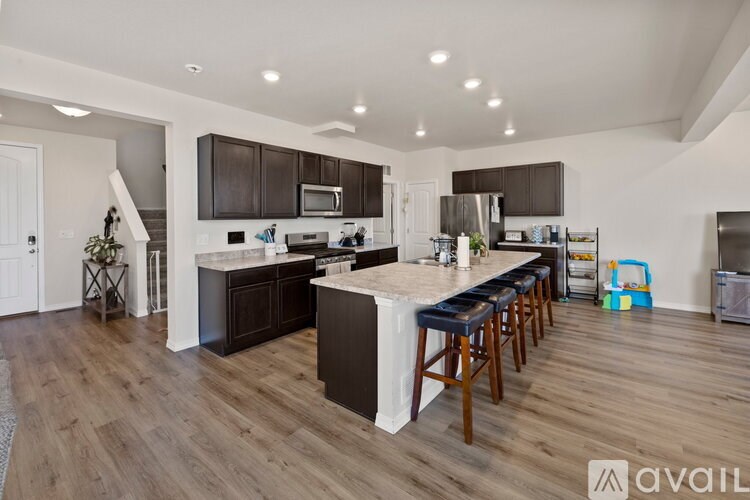 A modern kitchen with dark wood cabinets and a white island.