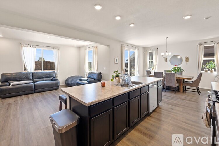 A modern kitchen with dark wood floors and a central island.