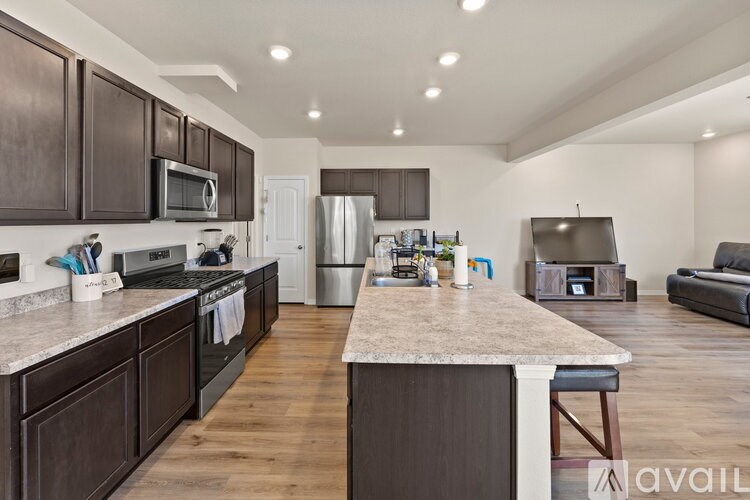 A kitchen with dark brown cabinets and a marble countertop.