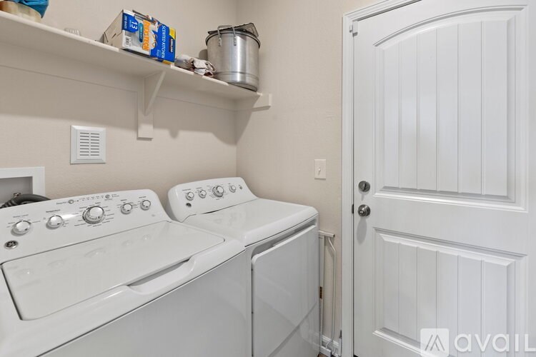 A white washing machine and dryer in a small laundry room.