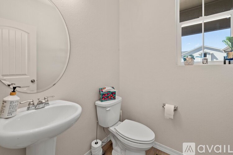 A white toilet sits next to a white sink in a bathroom.