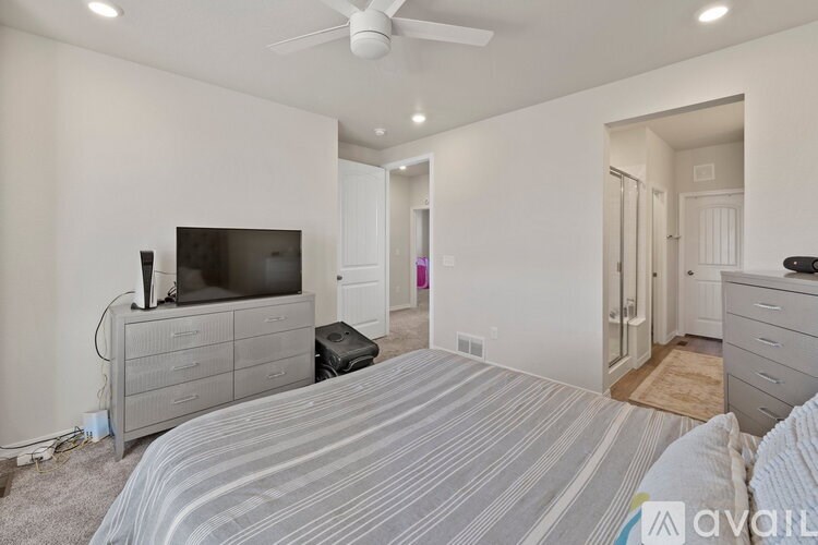 A bedroom with a bed, dresser, and television.