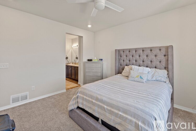 A bedroom with a large bed and a ceiling fan.