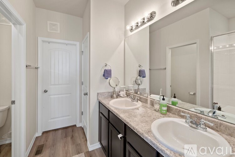 A bathroom with a sink, mirror, and a white door.