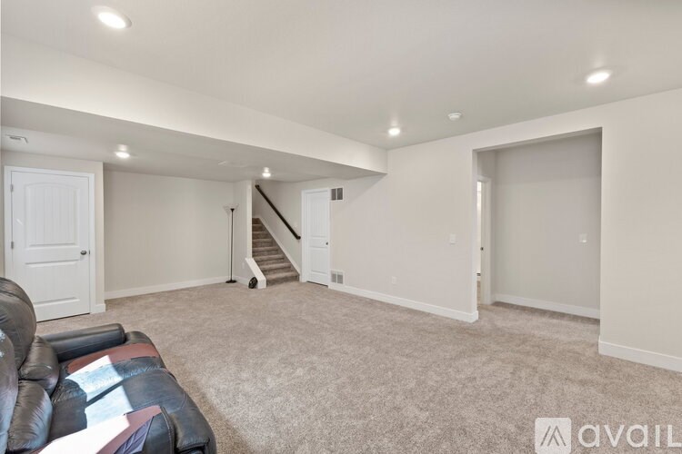 A living room with a couch and a staircase.