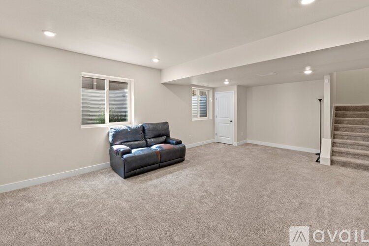 A living room with a grey sofa and a carpeted floor.