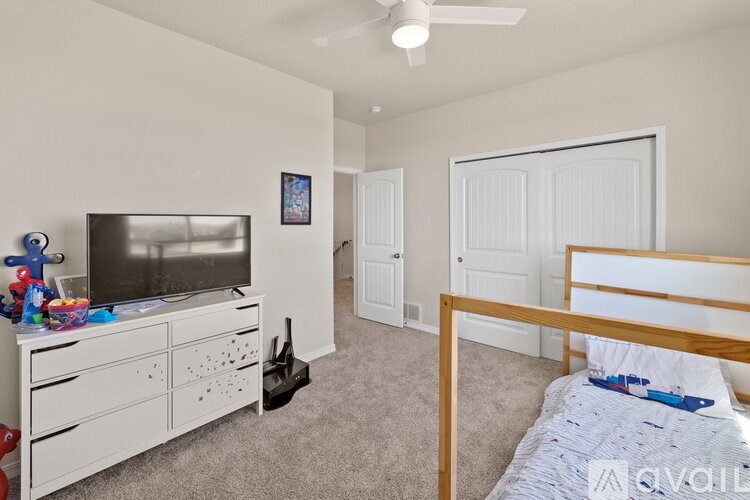 A bedroom with a bed, dresser, and television.