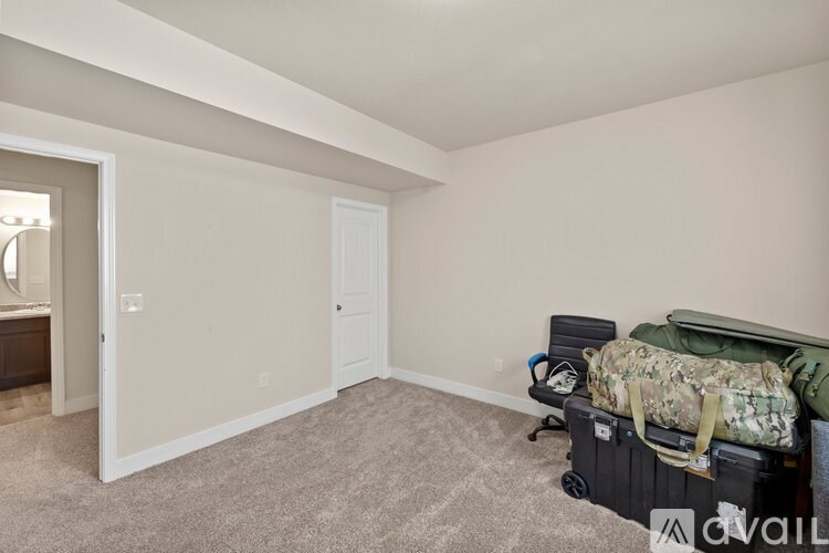 A room with a white door and a carpeted floor.