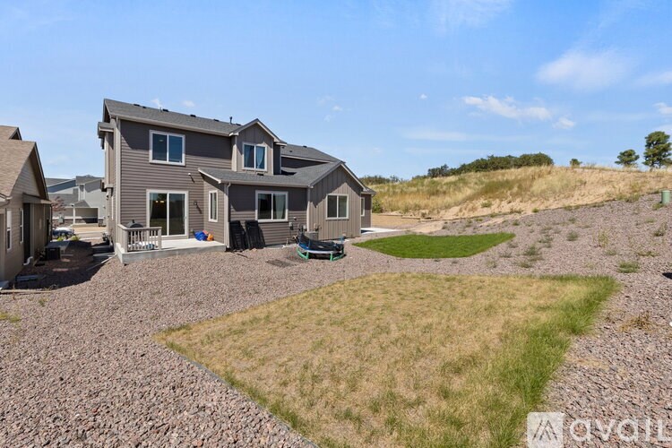 A house with a gravel driveway and a grassy area in front.