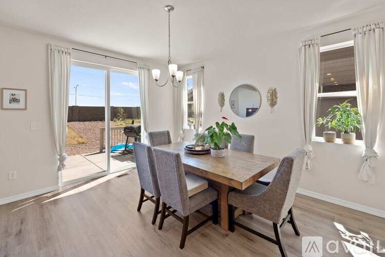 A dining room with a wooden table and grey chairs.