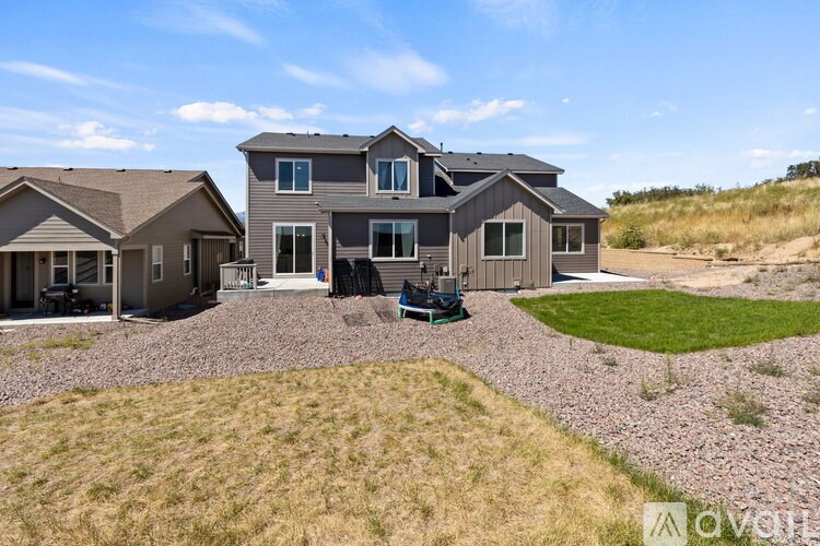 A house with a gravel driveway and a lawn in front.