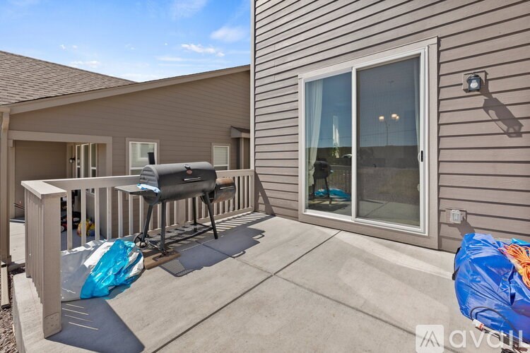 A patio with a grill and a covered table.