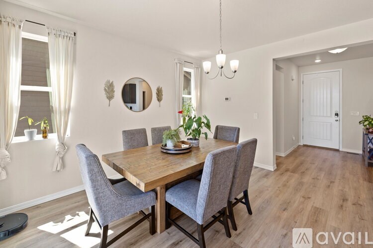 A dining room with a wooden table and grey chairs.