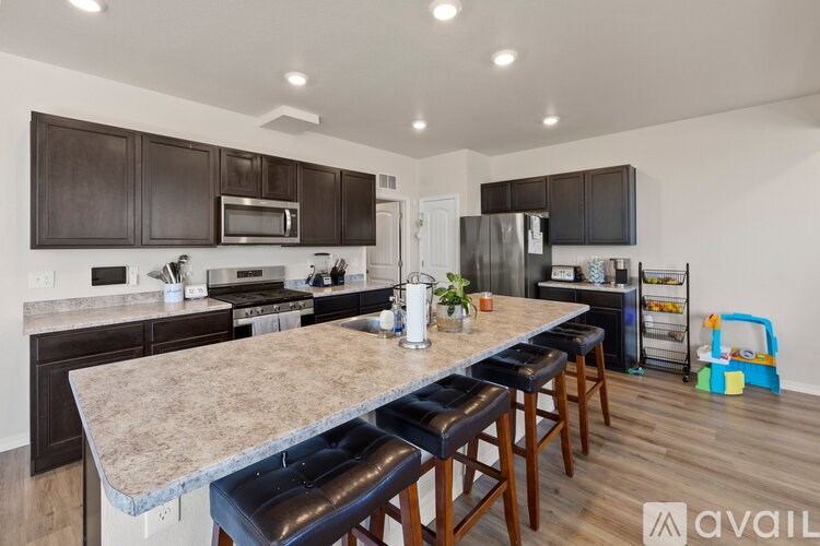 A kitchen with a granite countertop and bar stools.