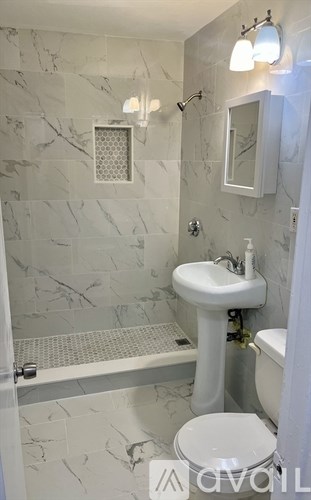 A white sink in a bathroom with marble tiles.