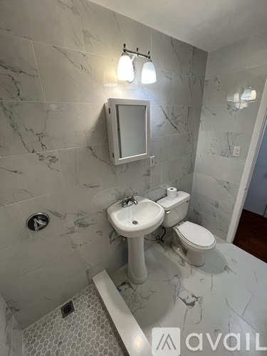 A bathroom with a sink, toilet and mirror.