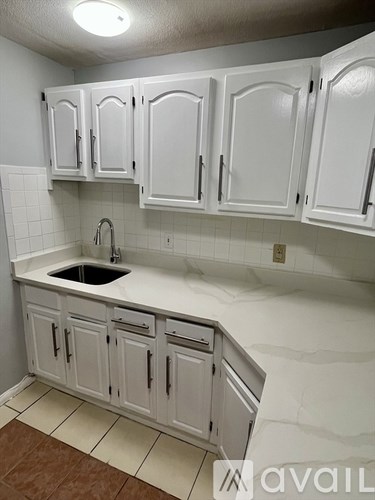 A kitchen with white cabinets and a sink.