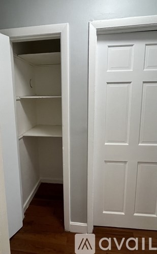 A white door with a white interior and a white shelving unit.