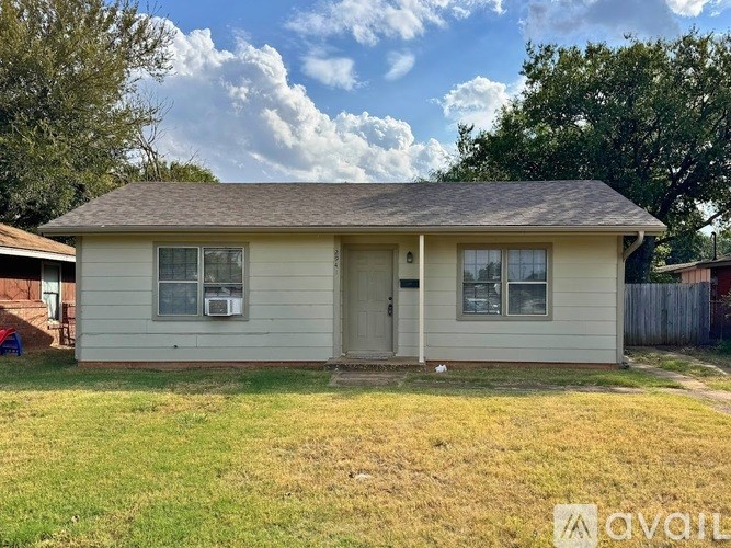 A house with a brown roof and a white wall is for sale.