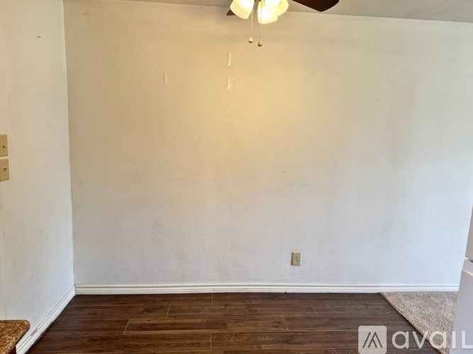 A room with wooden flooring and a ceiling fan.