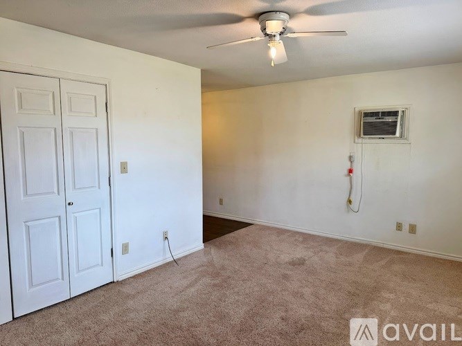 A room with a ceiling fan and a door.