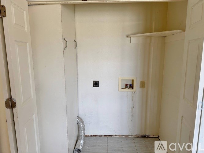 A white door with a hose coming out of it.