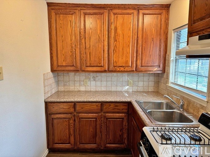 A kitchen with wooden cabinets and a stove top oven.