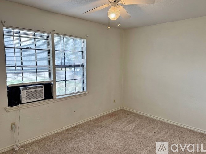 A room with a window and a fan on the ceiling.