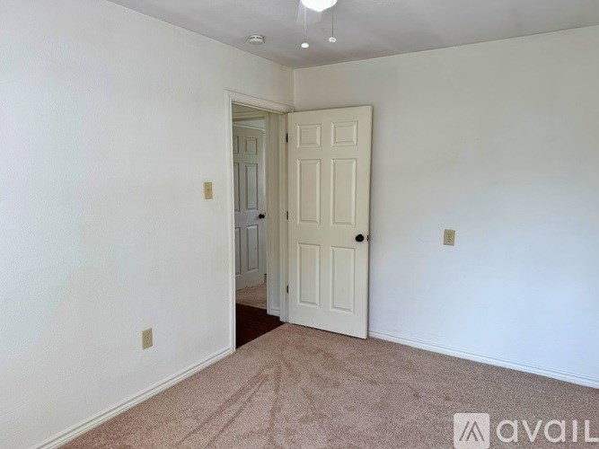 A room with a carpeted floor and a white door.