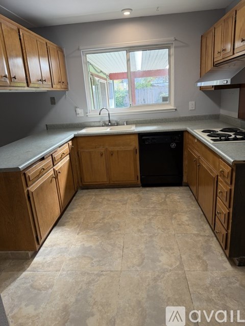A kitchen with wooden cabinets and a tiled floor.
