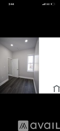 A room with wooden flooring and white walls.