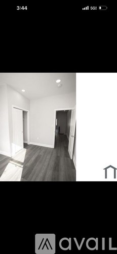 A black and white image of a hallway with a door on the left and a door on the right.