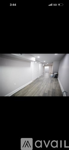 A long hallway with a couch and a chair at the end.