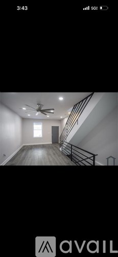A room with a ceiling fan and a staircase.