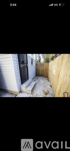 A white house with a black door and a wooden fence.