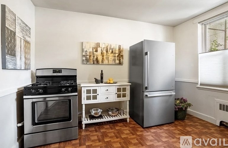 A kitchen with a stove, refrigerator, and a small table with a bowl on it.