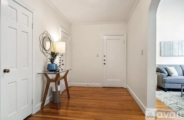 A hallway with a table and a plant on it.