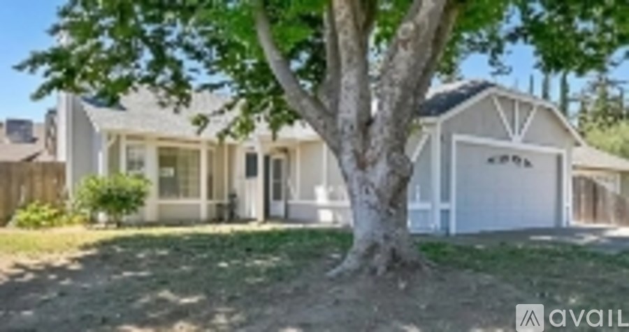 A house with a tree in front of it is for sale.