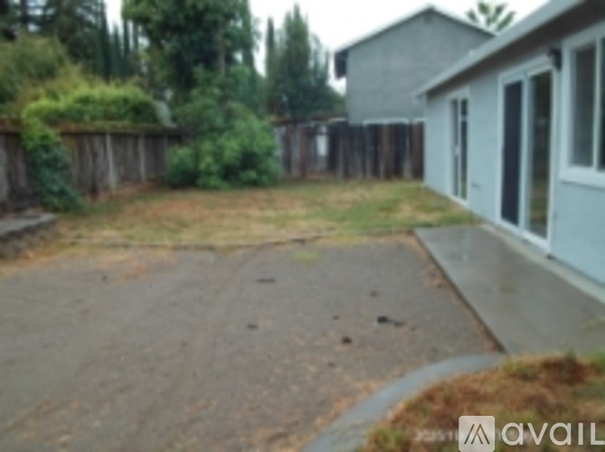 A backyard with a fence and a house.
