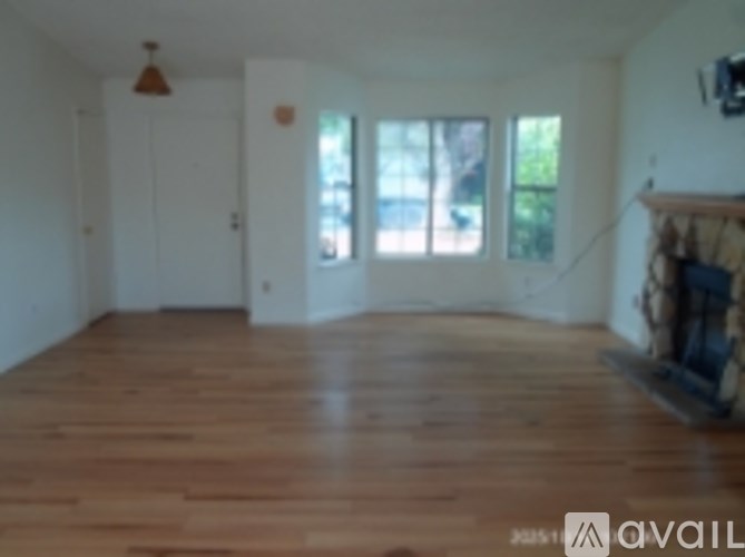 A living room with a fireplace and a flat screen TV mounted on the wall.