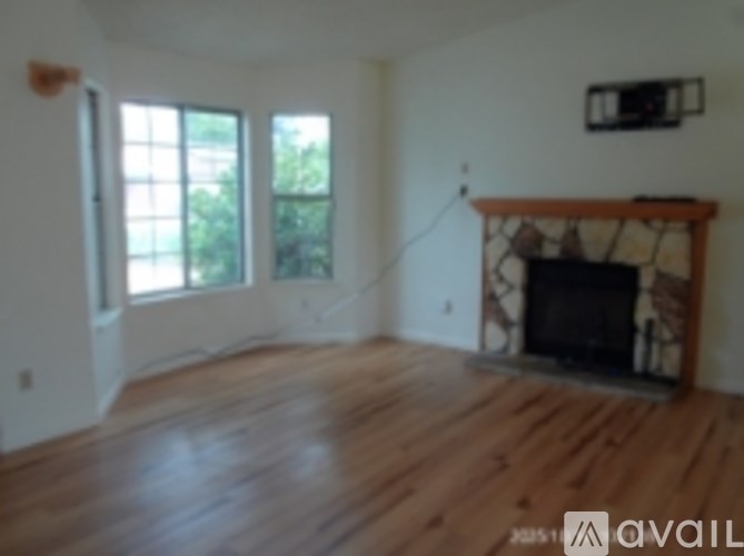 A living room with a fireplace and a tv on the wall.