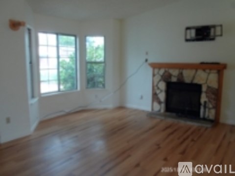 A living room with a fireplace and a tv on the wall.