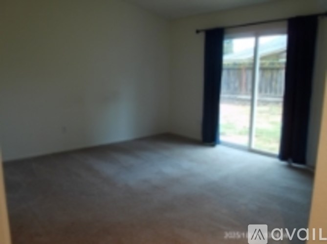 A room with a sliding glass door leading to a backyard.