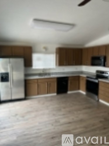 A kitchen with wooden cabinets and a stainless steel refrigerator.