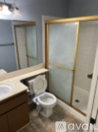 A bathroom with a toilet, sink, and shower.