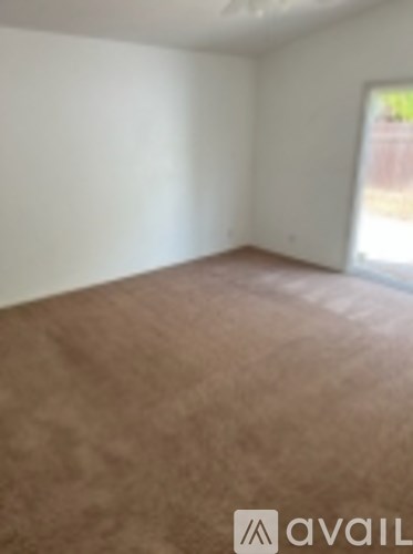 A room with brown carpet and white walls.