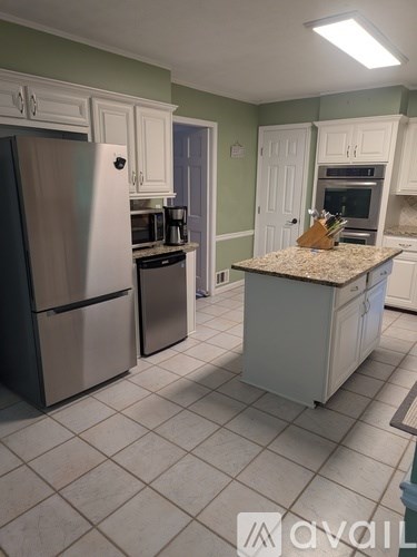 A kitchen with a refrigerator, oven, and microwave.